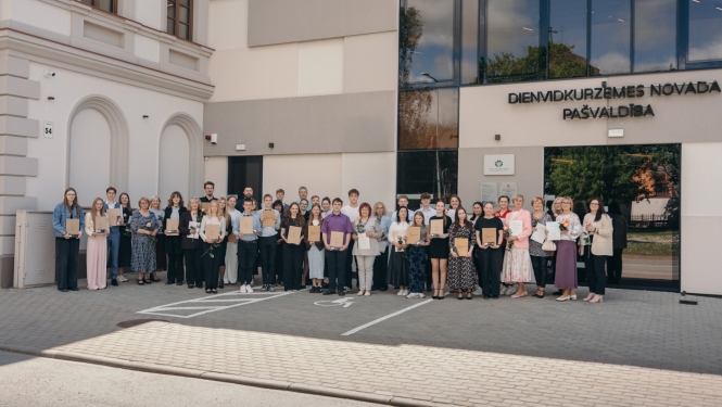 Skolēni stāv kopīgā foto ar diplomiem