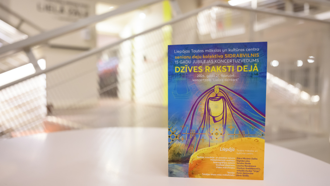 Uz galda novietots krāsains plakāts modernā, gaišā interjerā ar izplūdušu fonu