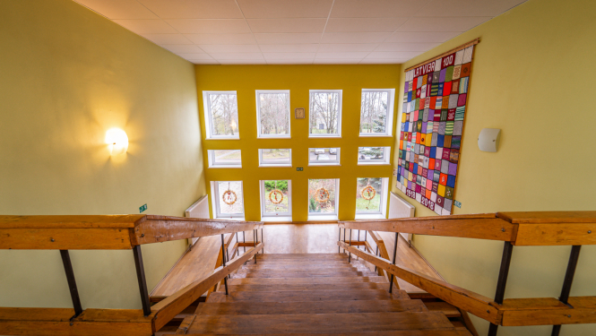 Iekštelpu kāpnes, kas ved uzleju pretī lielam logam