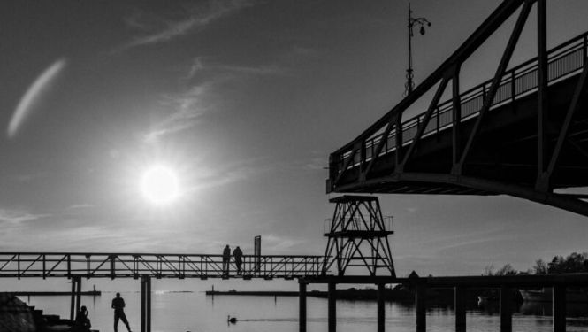 melnbaltā fotogrāfija. Redzams tilts