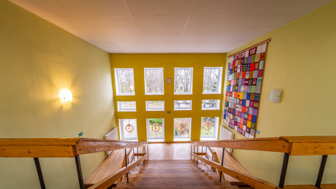 Iekštelpu kāpnes, kas ved uzleju pretī lielam logam