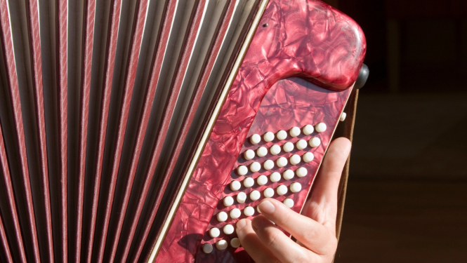 Rokās tiek turēts akordeons