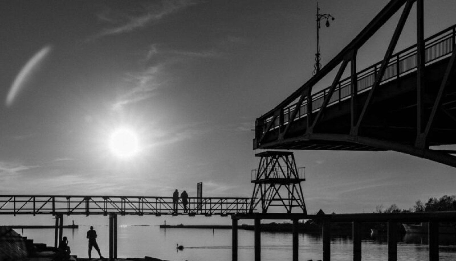 melnbaltā fotogrāfija. Redzams tilts