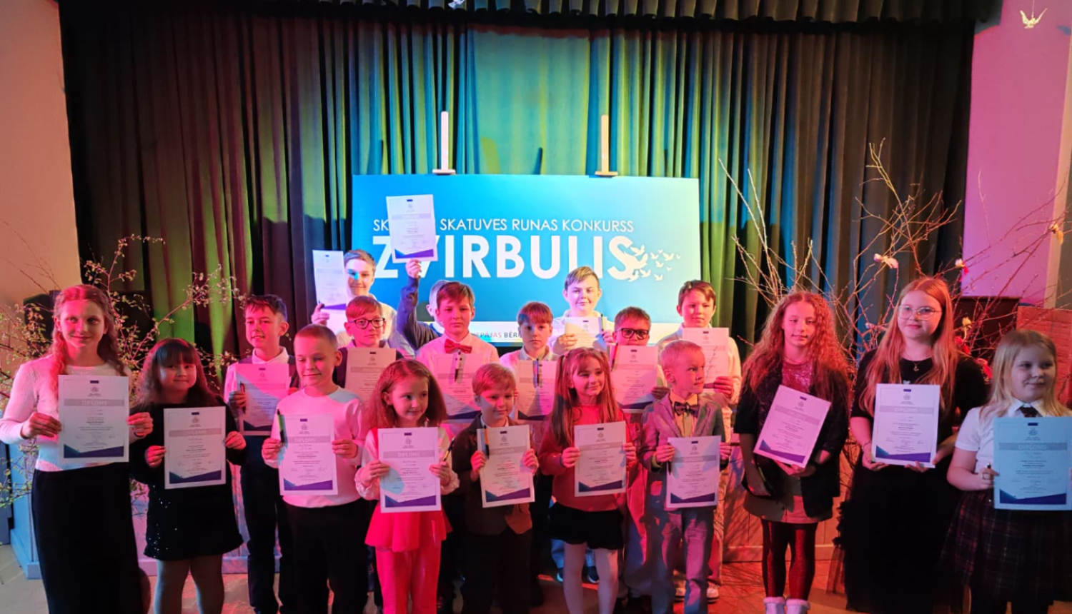 Skolēni stāv kopīgā foto ar diplomiem